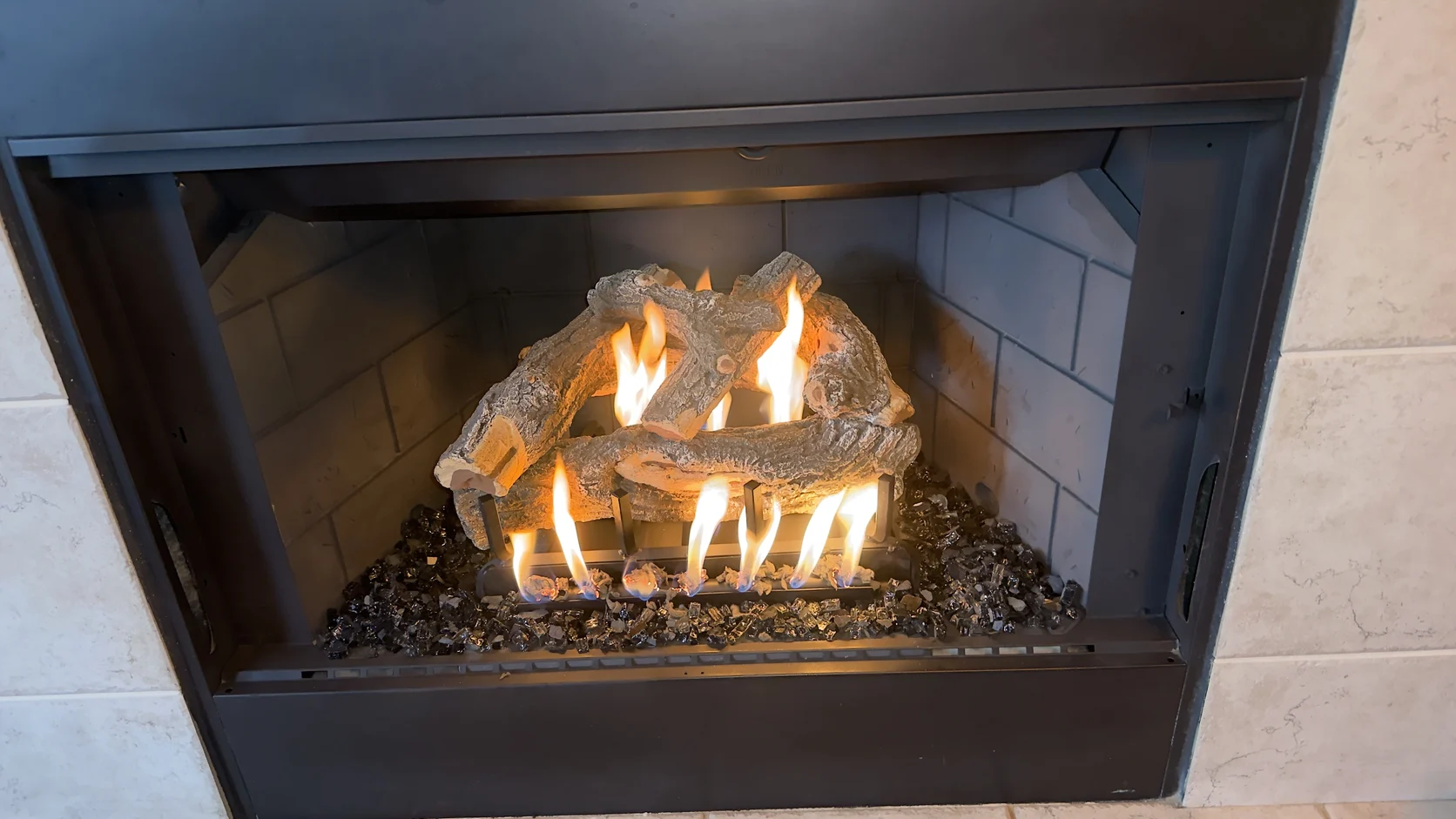 Gas log set burning in a black metal firebox